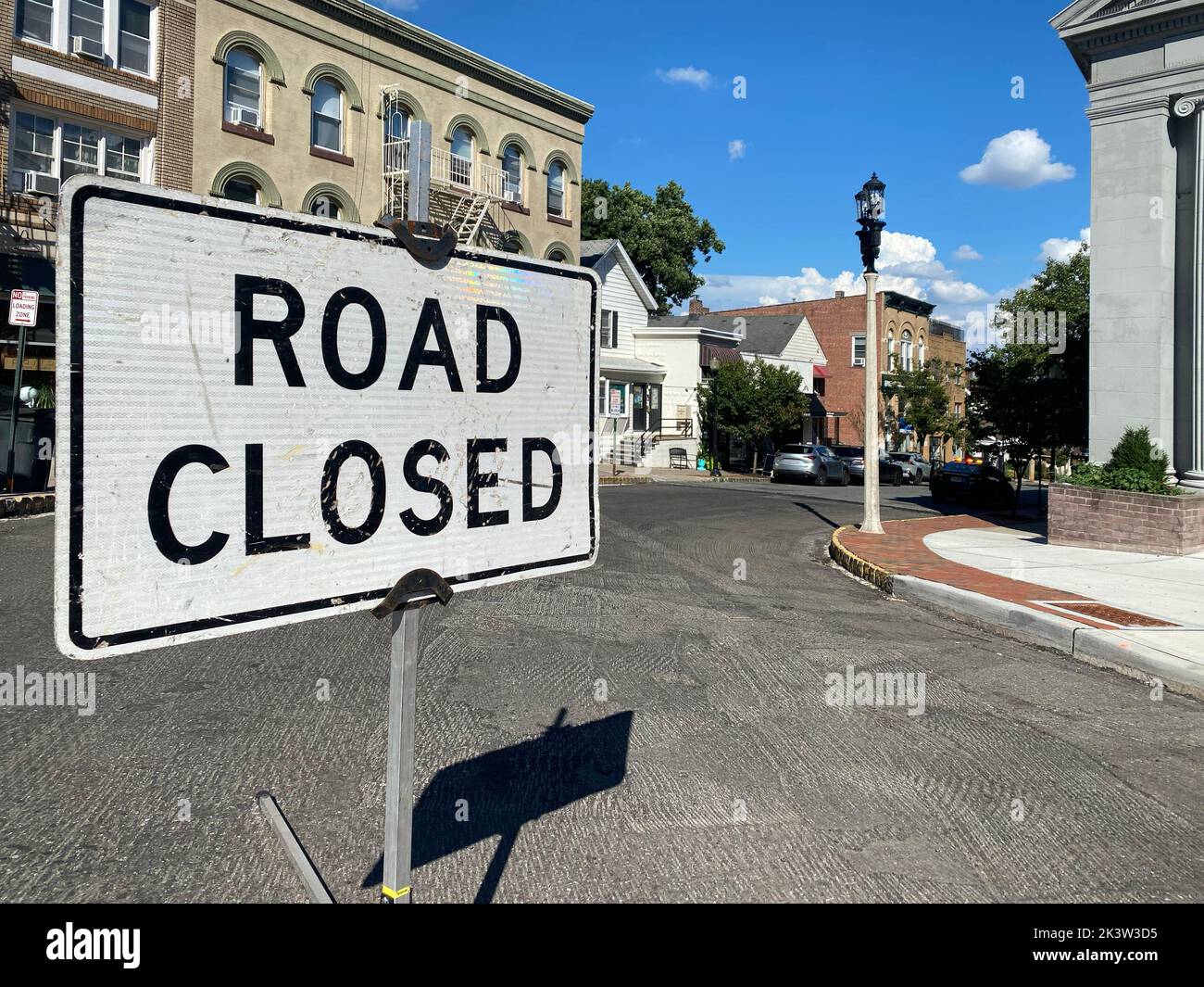 Carretera señalización cerrada en blanco y negro en la calle de la ciudad con desarraigado viejo asfalto Foto de stock
