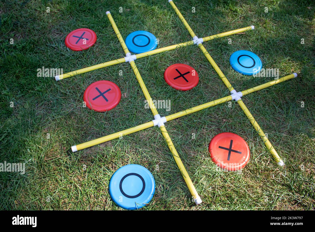 Las X y O físicas de un juego de césped de la diversión de los niños Foto de stock