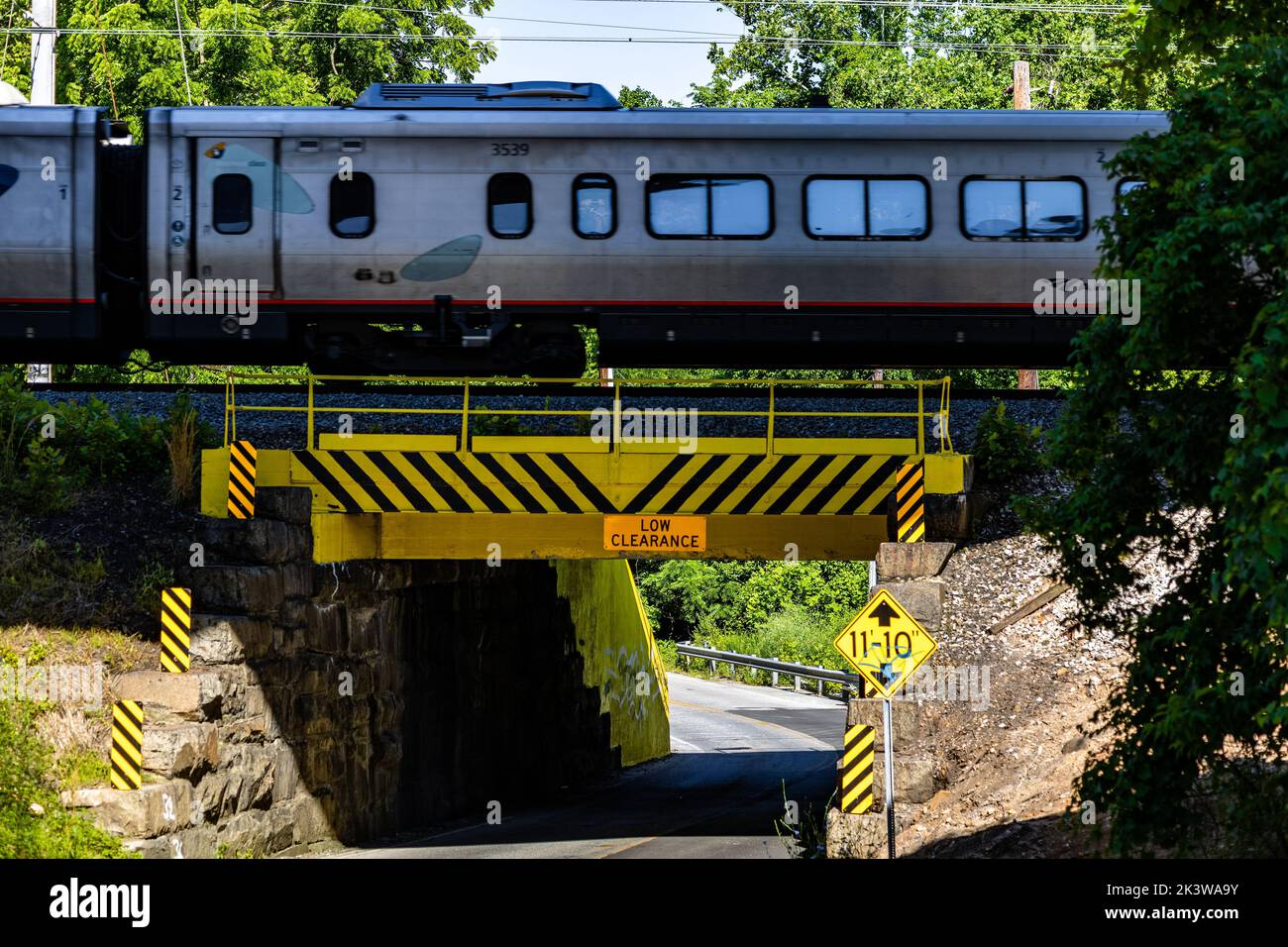 Un tren en el puente sobre la carretera en un día soleado Foto de stock
