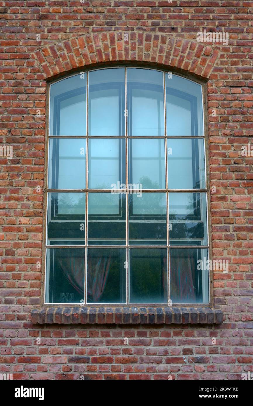 antigua ventana de un edificio de ladrillo rojo Foto de stock