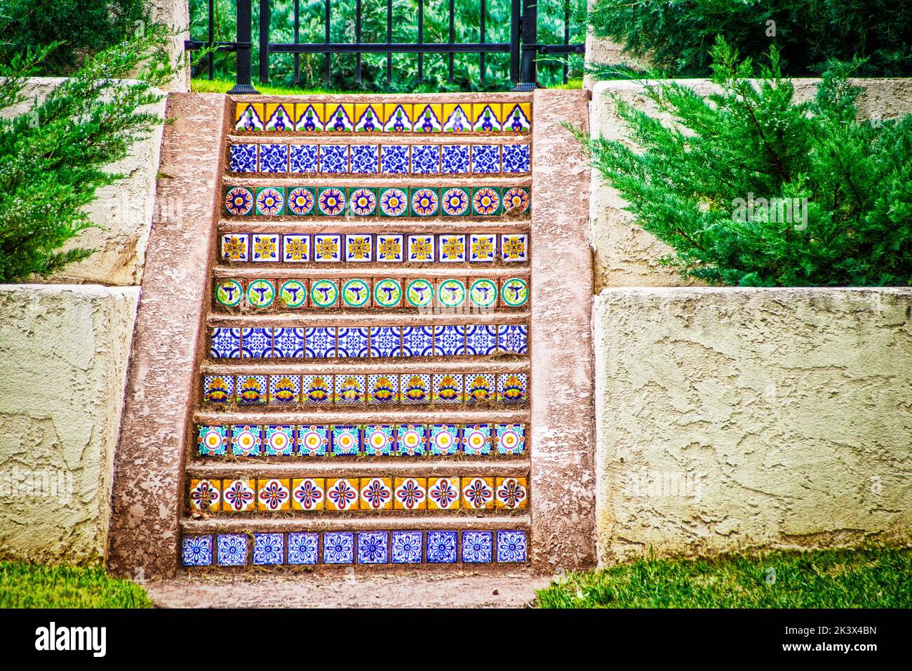 Hermosos y coloridos azulejos mejicanos toscanos escalones al aire libre rodeados de paredes de estuco y paisajismo Foto de stock