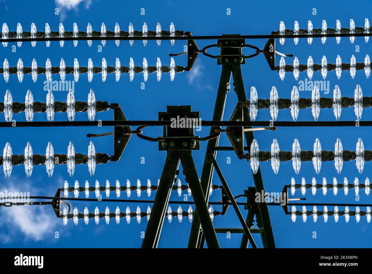 Aisladores hechos de vidrio en una línea de alta tensión, en los postes cuelgan como un dispositivo de suspensión entre el poste y el cable vivo, no aislado, ext Foto de stock