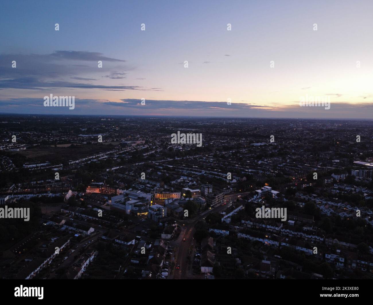 Toma aérea de una puesta de sol naranja sobre una ciudad moderna durante la noche Foto de stock