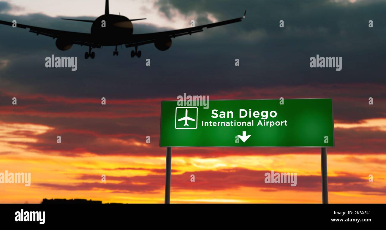 Aterrizaje de silueta de avión en San Diego, California, EE.UU. Llegada a la ciudad con un cartel de dirección al aeropuerto y puesta de sol en segundo plano. Viaje y transporte Foto de stock