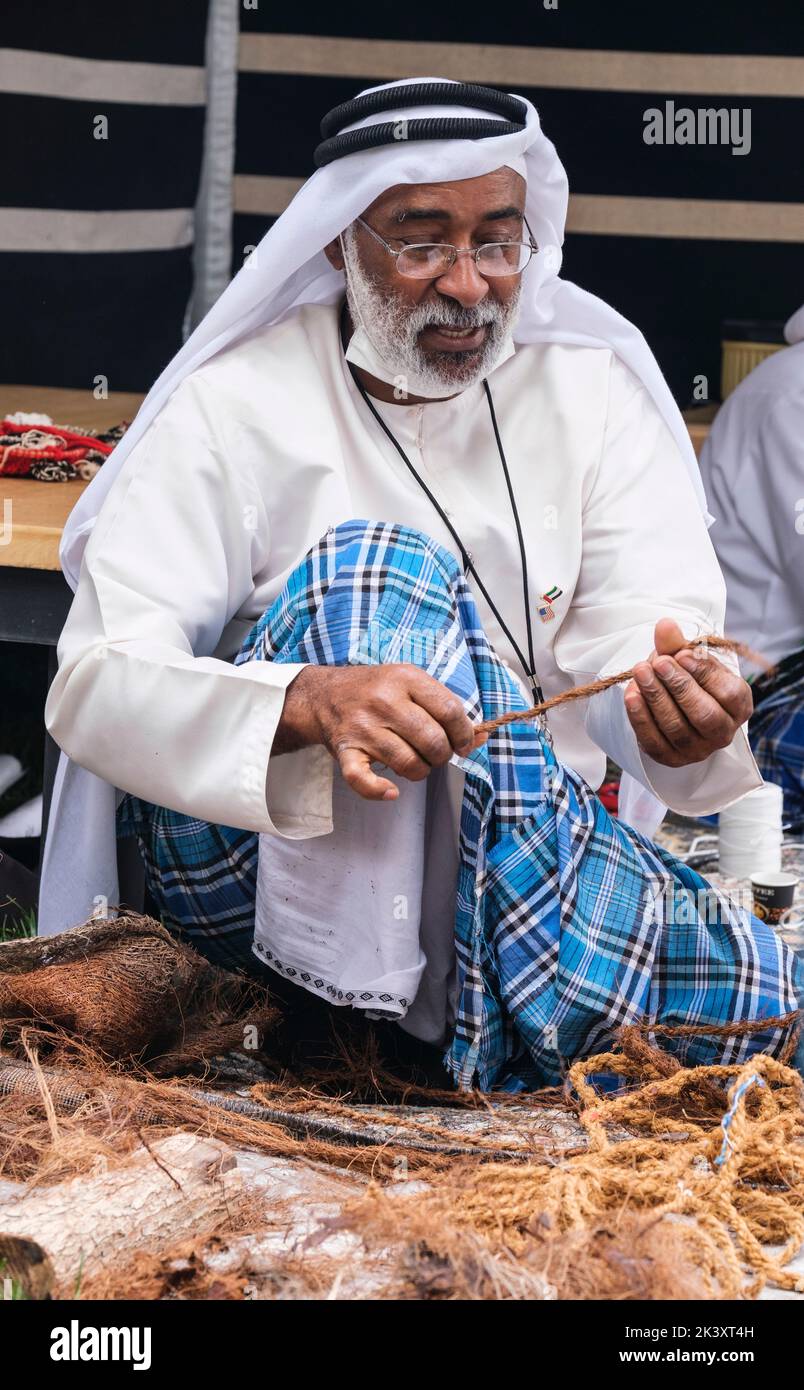 Afro-árabe de Abu Dhabi en el Festival Folklife en Dishdasha, Ghutra y Agal, haciendo cuerda de fibra de coco para su uso en la fabricación de redes de pesca tradicionales. Foto de stock