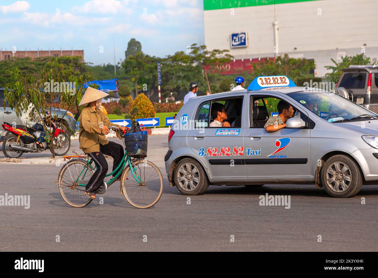 Mujer vietnamita usando sombrero cónico de bambú, con bicicleta, Hai Phong, Vietnam Foto de stock