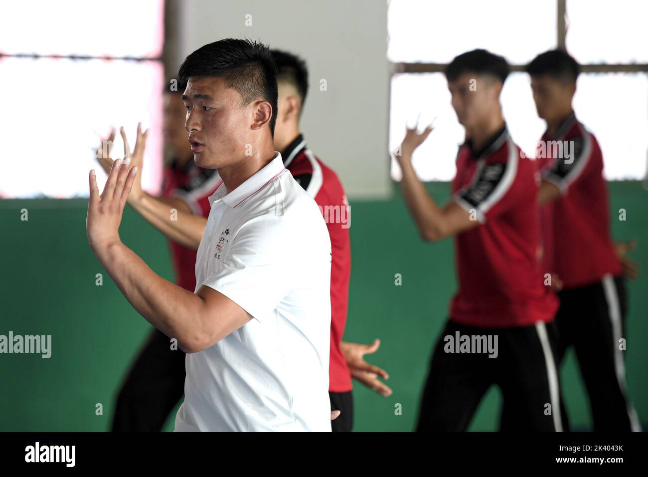 (220929) -- ZHENGZHOU, 29 de septiembre de 2022 (Xinhua) -- Li Yinggang (Frente) instruye a los estudiantes durante una clase de artes marciales en la Escuela de Artes Marciales Shaolin Tagou en Songshan, provincia central de Henan en China, 6 de julio de 2022. Li Yinggang, de 25 años, es entrenador de la Escuela de Artes Marciales Shaolin Tagou en Songshan, en la provincia de Henan, en el centro de China. Comenzó la práctica de las artes marciales a la edad de 9 años y cambió al combate libre 3 años más tarde. Desde que tenía 16 años, Li ha participado en las competiciones profesionales de combate libre, ganando los títulos de eventos nacionales e internacionales varias veces incluido Foto de stock