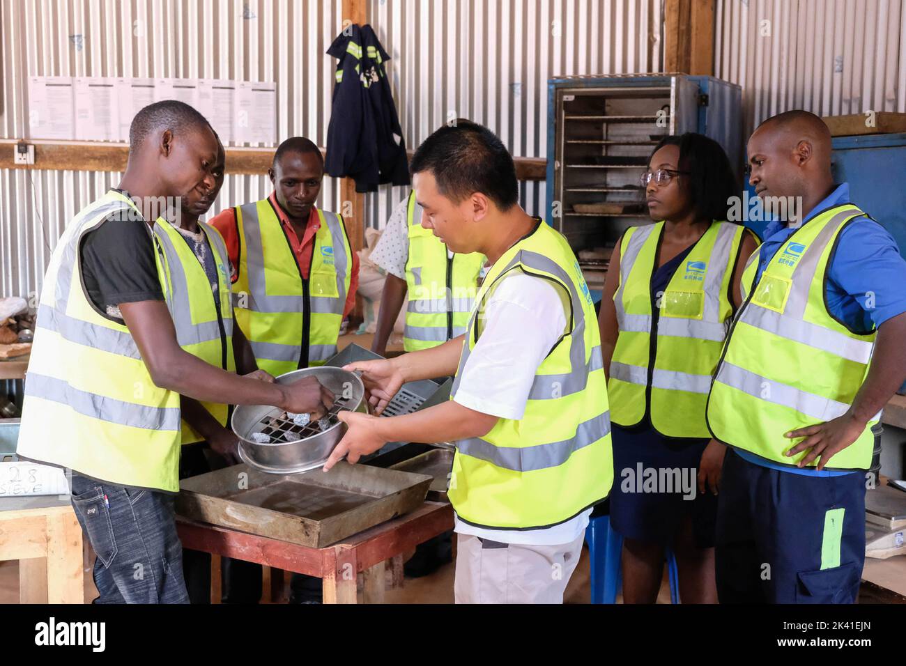 Wakiso, Uganda. 24th de Sep de 2022. LYU Yong (2nd L, FRONT), ingeniero de Chongqing International Construction Corporation (CICO), interactúa con los trabajadores dentro de un laboratorio en el campamento base en el centro comercial de Kiti, en el distrito de Wakiso, Uganda, 24 de septiembre de 2022. PARA IR CON 'Reportaje: Técnicos chinos mentor jóvenes ingenieros ugandeses para hacerse cargo del futuro' Crédito: Hajarah Nalwadda/Xinhua/Alamy Live News Foto de stock