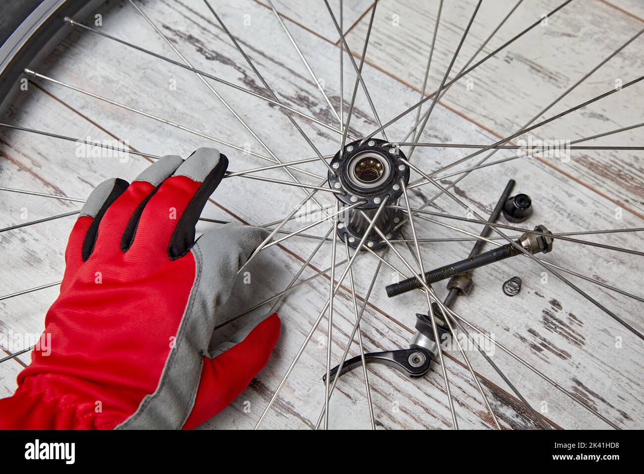 Desmontar y lubricar con aceite los rodamientos de la rueda de bicicleta. Reparación de bicicletas por cuenta propia Foto de stock