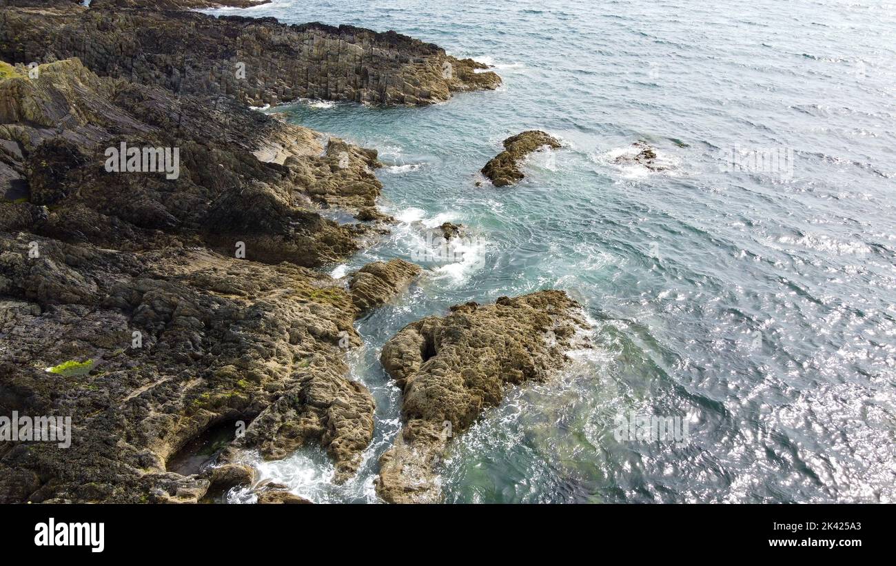 Costa salvaje del Océano Atlántico. Pequeñas ondas y el sol resplandece en la superficie del agua. Paisaje costero en un día soleado. Foto aérea. Punto de drone Foto de stock