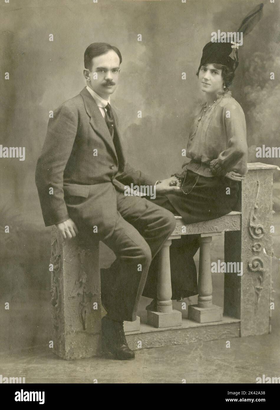 Retrato de estudio de una pareja sentada en un baluster, Italia 1920s Foto de stock