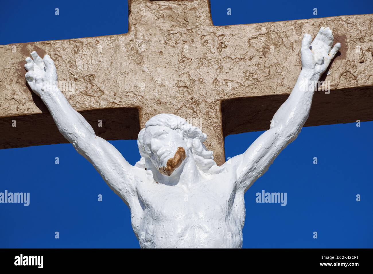 Estatua de Cristo en la cruz contra un cielo azul en Francia Foto de stock
