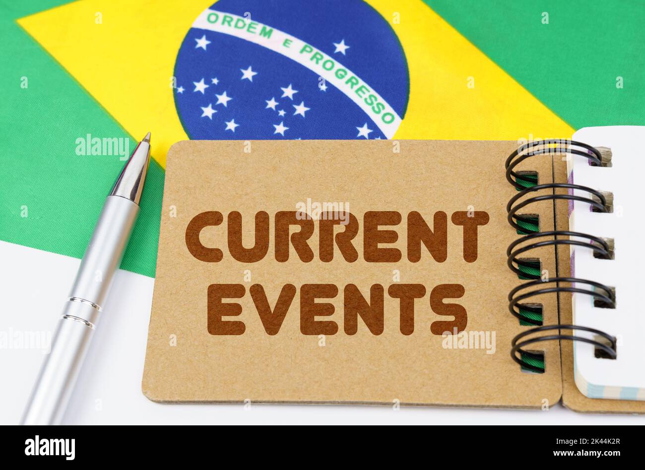 Concepto de economía nacional. En la bandera de Brasil se encuentra un cuaderno con la inscripción - los acontecimientos actuales Foto de stock