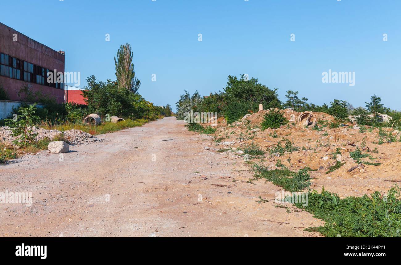 Carretera a lo largo de la Estación de Energía Atómica de Crimea abandonada en un día soleado. Cabo Kazantyp paisaje, Crimea Foto de stock