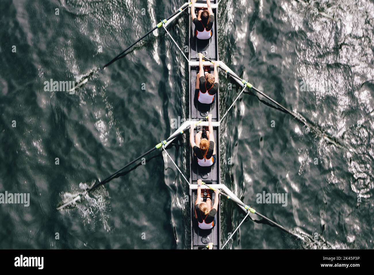 Vista aérea de las tripulantes femeninas remando en una concha de carreras octuple, un equipo de ochos. Foto de stock