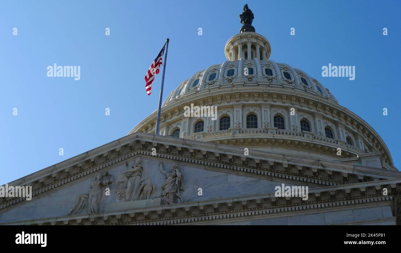 Vista de ángulo bajo del histórico landmkark, el edificio del Capitolio en Washington DC, bandera ondeando, una cúpula y estatua. Foto de stock