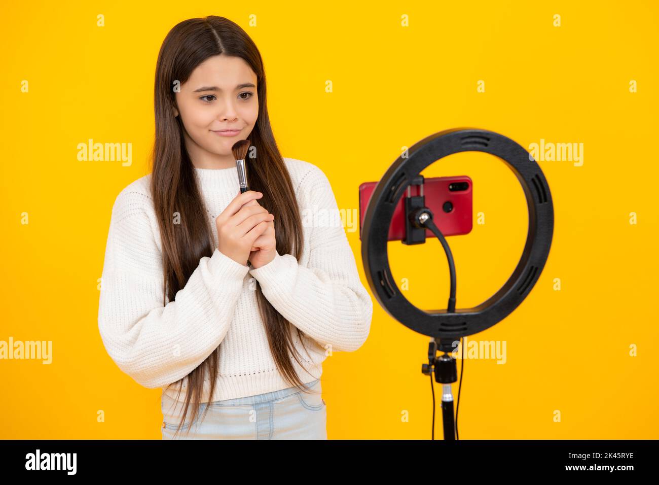 Belleza blog. Chica joven blogger influencer usar selfie lámpara LED y smartphone en trípode para hacer tutorial de vídeo en línea. Vlogger adolescente haciendo vlog Foto de stock