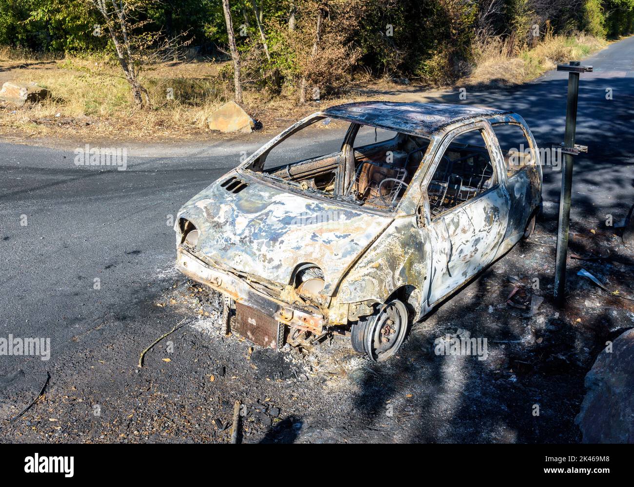 Un coche de la ciudad se quemó en una calle discreta de un barrio sensible. Foto de stock