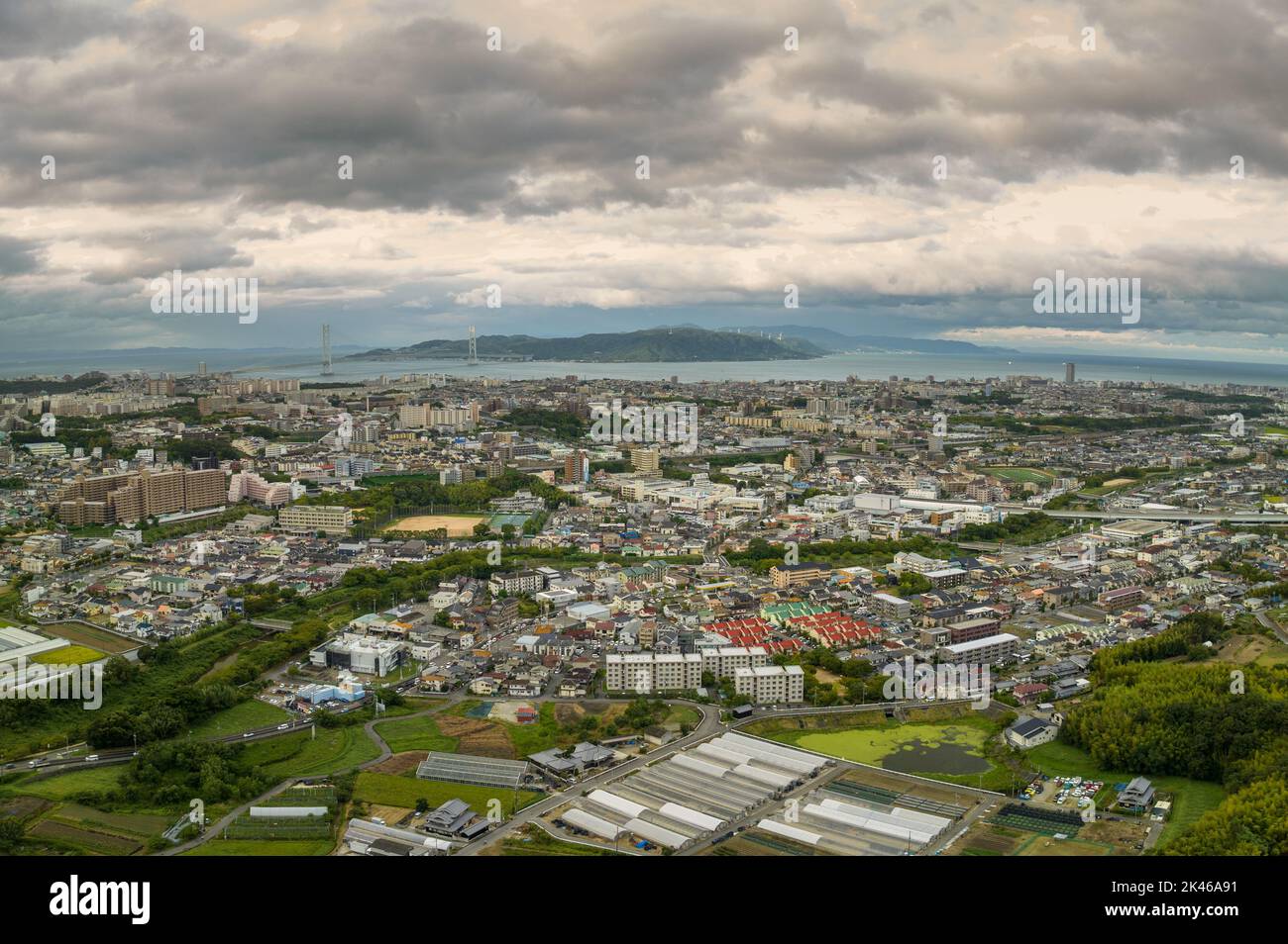 Vista aérea de la extensa ciudad costera con nubes de tormenta por encima Foto de stock