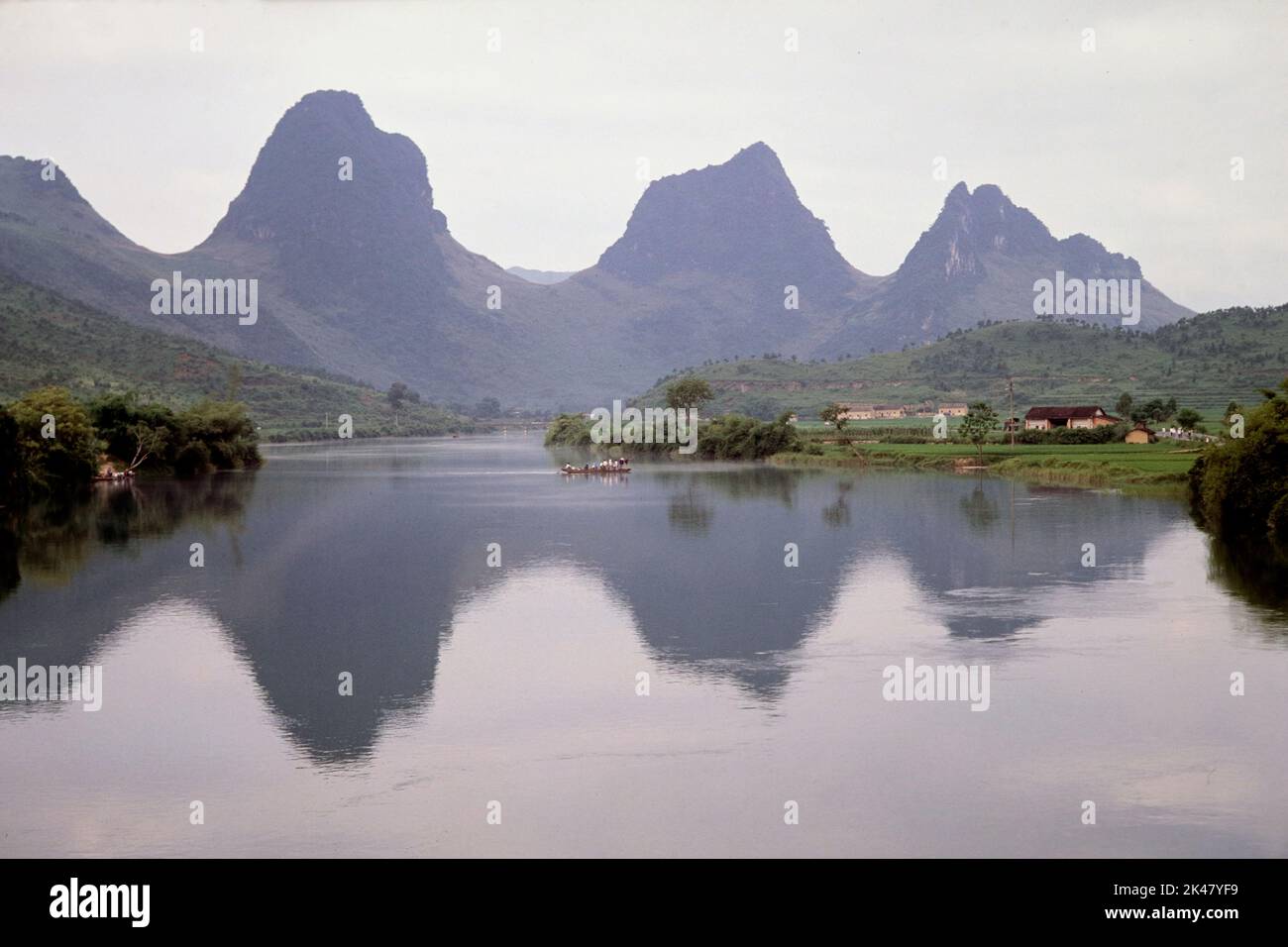 Vista horizontal de un paisaje kárstico, colinas y reflexiones a lo largo del río oeste, cerca de Shaoguan, provincia de Guangdong, China Junio 1988 Foto de stock