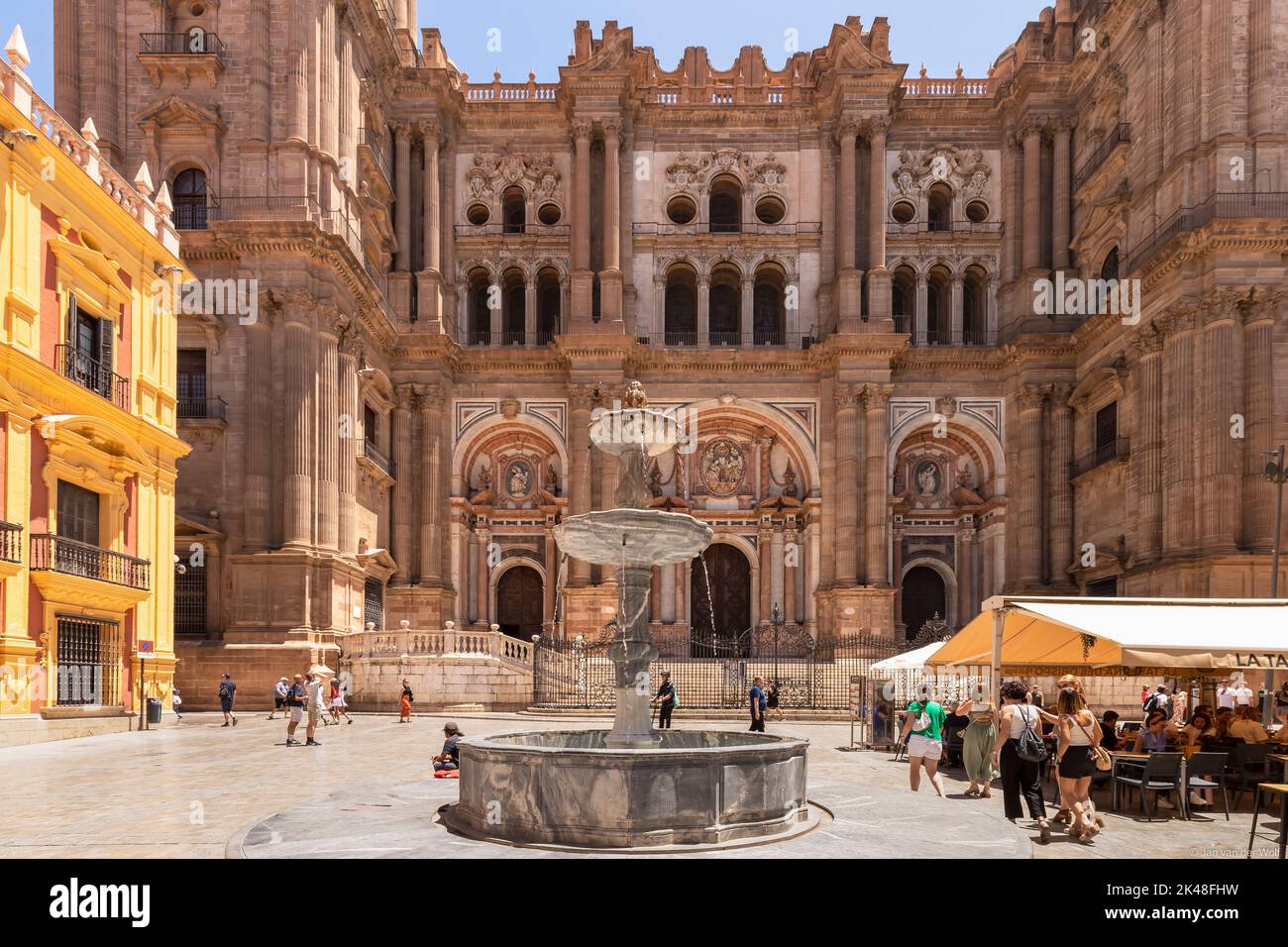 Fachada de la Catedral de Málaga o Santa Iglesia Catedral Basílica de la Encarnación, con una fuente y turistas en la plaza del pueblo en primer plano Foto de stock