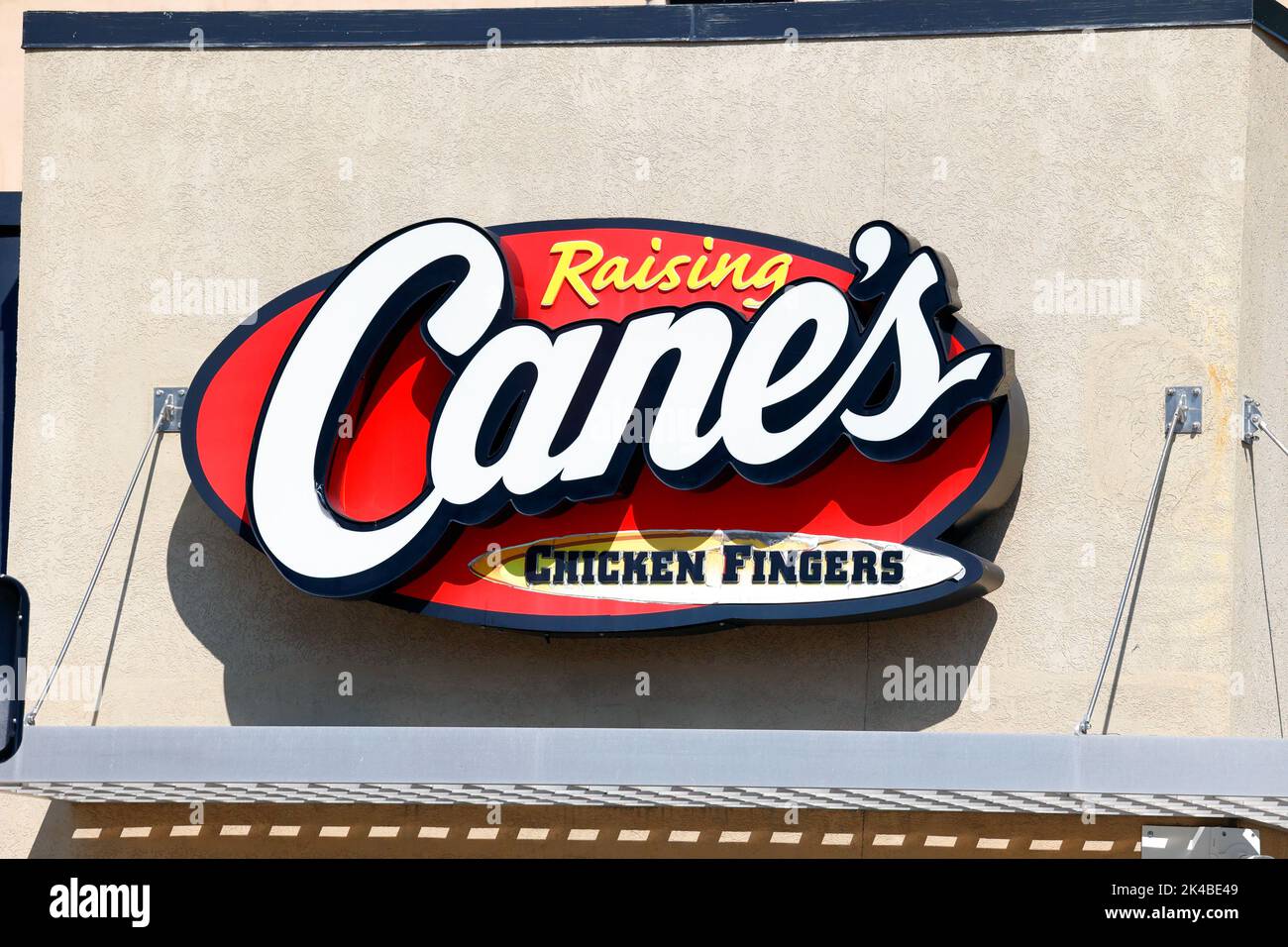 Una señalización de comida rápida Raising Cane's Chicken Fingers en un edificio de Boston Foto de stock