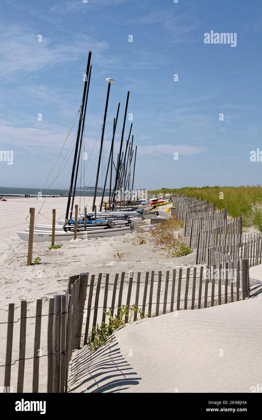 Una línea de catamaranes atado en una playa de arena Foto de stock