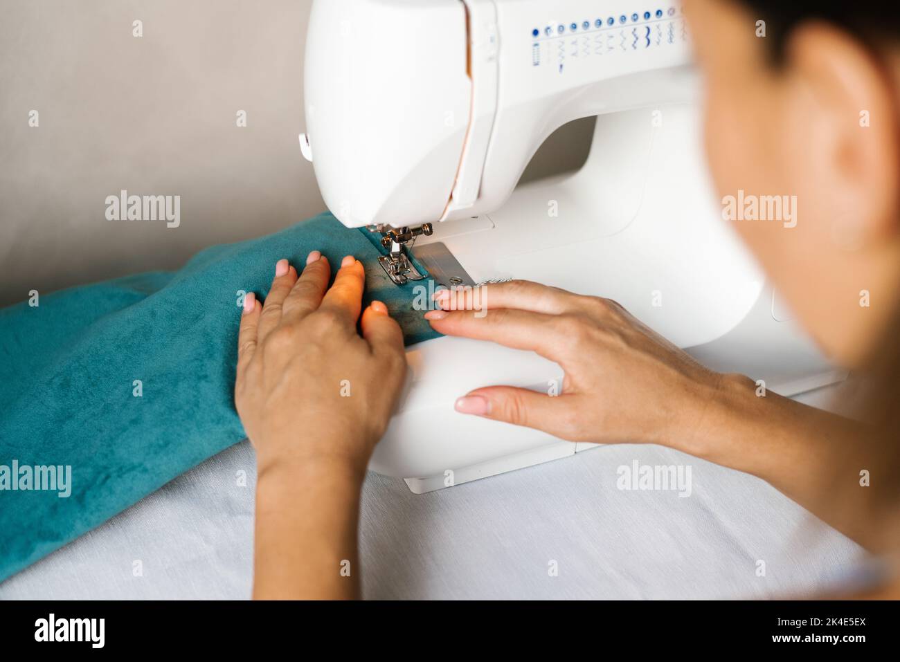 Máquina de coser con las manos, primer plano. Sastrería de diseño individual. Foto de stock