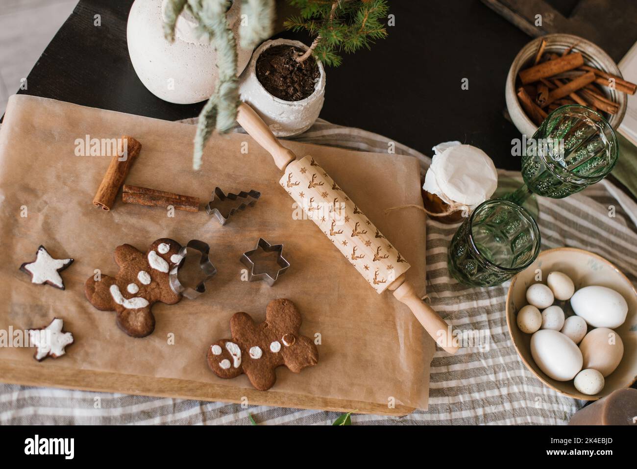 Galletas de Navidad de jengibre caseras decoradas con glaseado en la mesa en estilo rústico Foto de stock
