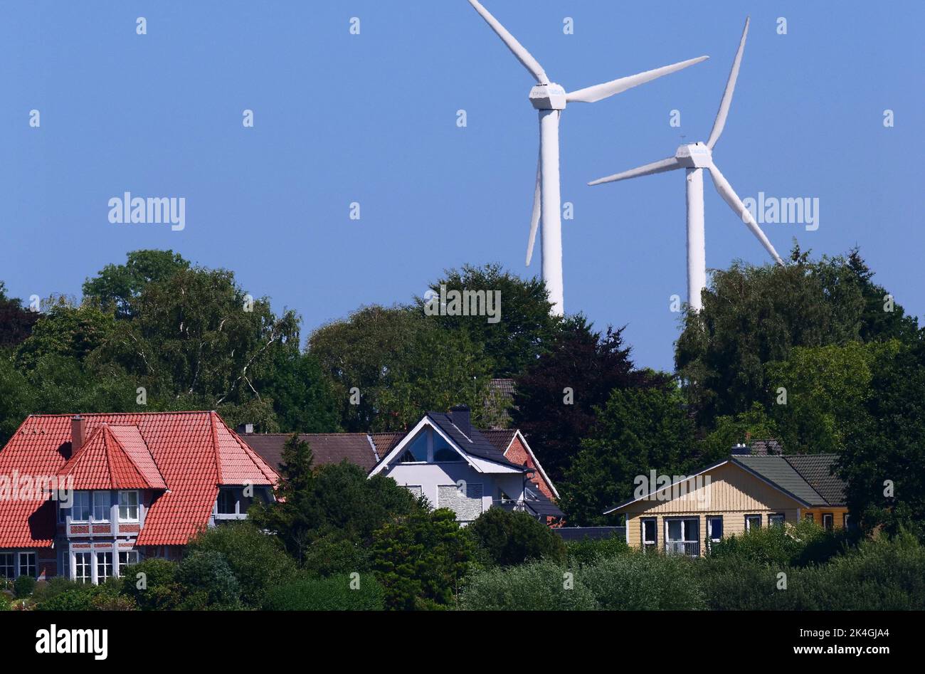 Kappeln, Alemania. 12th de Ago de 2022. 12.08.2022, Kappeln en el Schlei. Molinos de viento para la generación de energía están detrás de casas residenciales cerca de Kappeln. Crédito: Wolfram Steinberg/dpa Crédito: Wolfram Steinberg/dpa/Alamy Live News Foto de stock