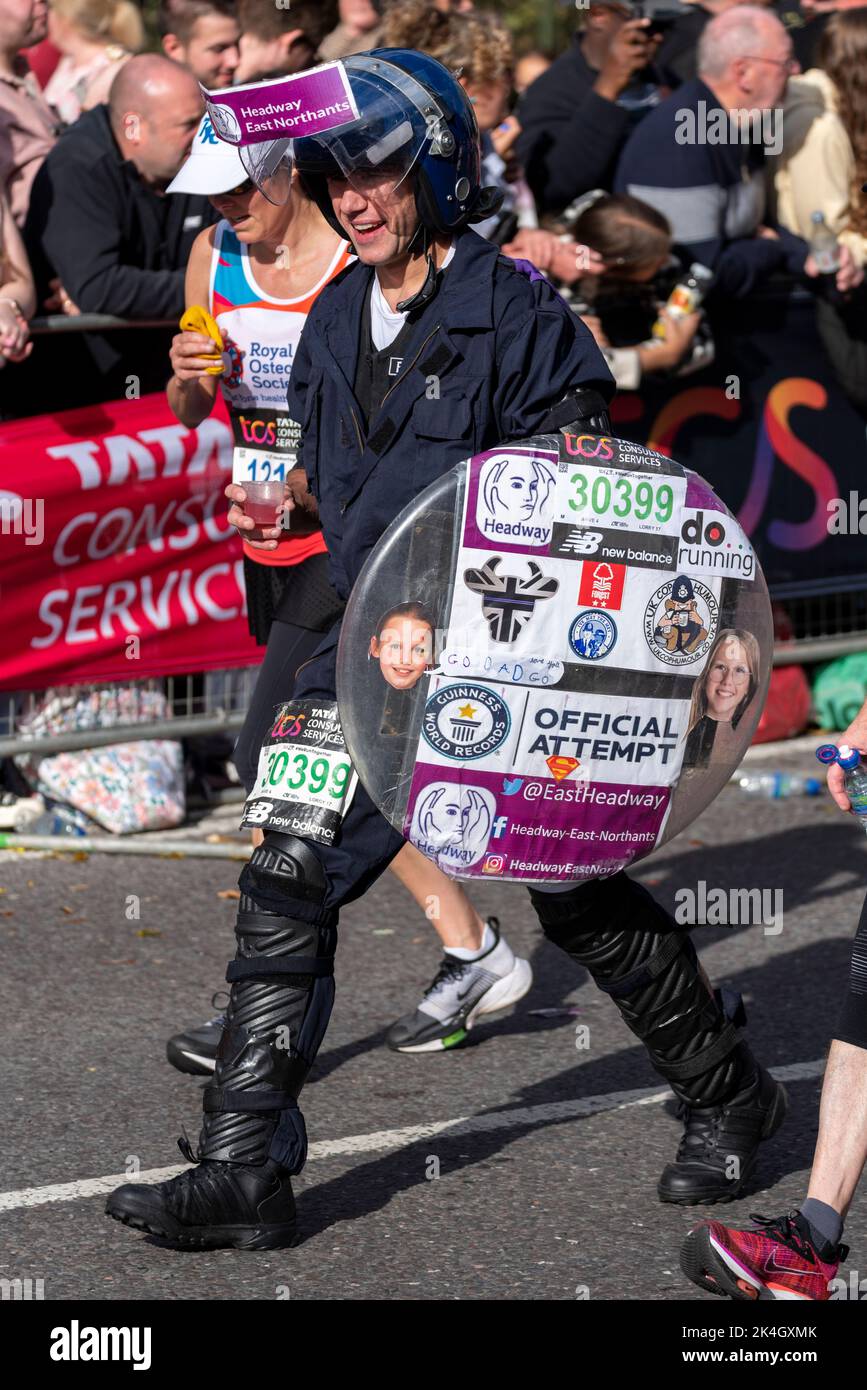 Thomas Bolton corriendo en el TCS London Marathon 2022, en Tower Hill Road, City of London, Reino Unido, con equipo antidisturbios de la policía. Intento de registro oficial Foto de stock