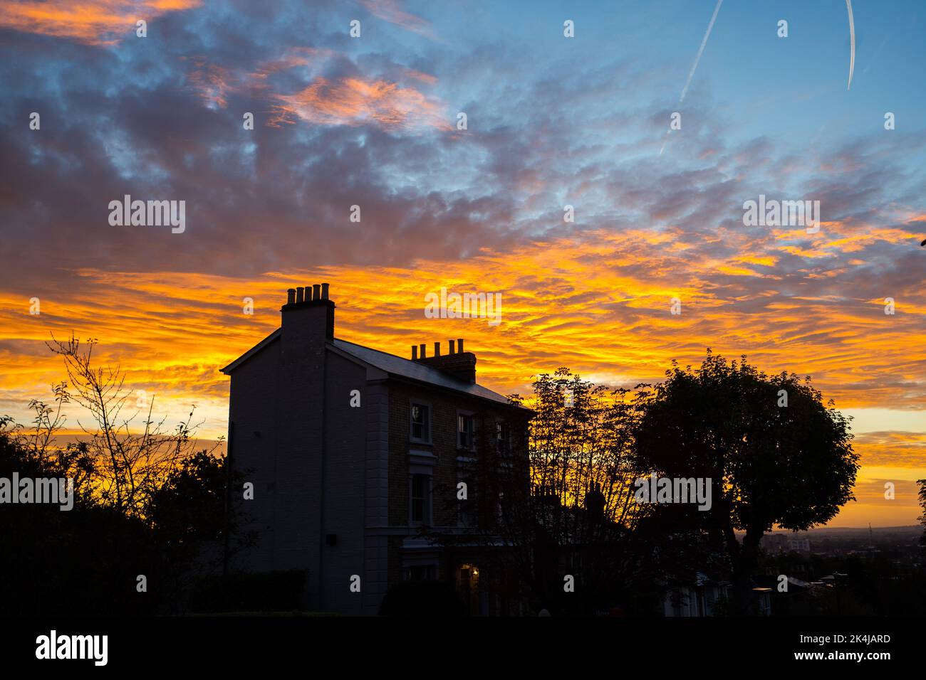 Londres, Reino Unido. 3 de octubre de 2022 . Un edificio residencial en Wimbledon, al suroeste de Londres, se perfila contra un espectacular amanecer colorido Crédito: amer ghazzal/Alamy Live News. Foto de stock