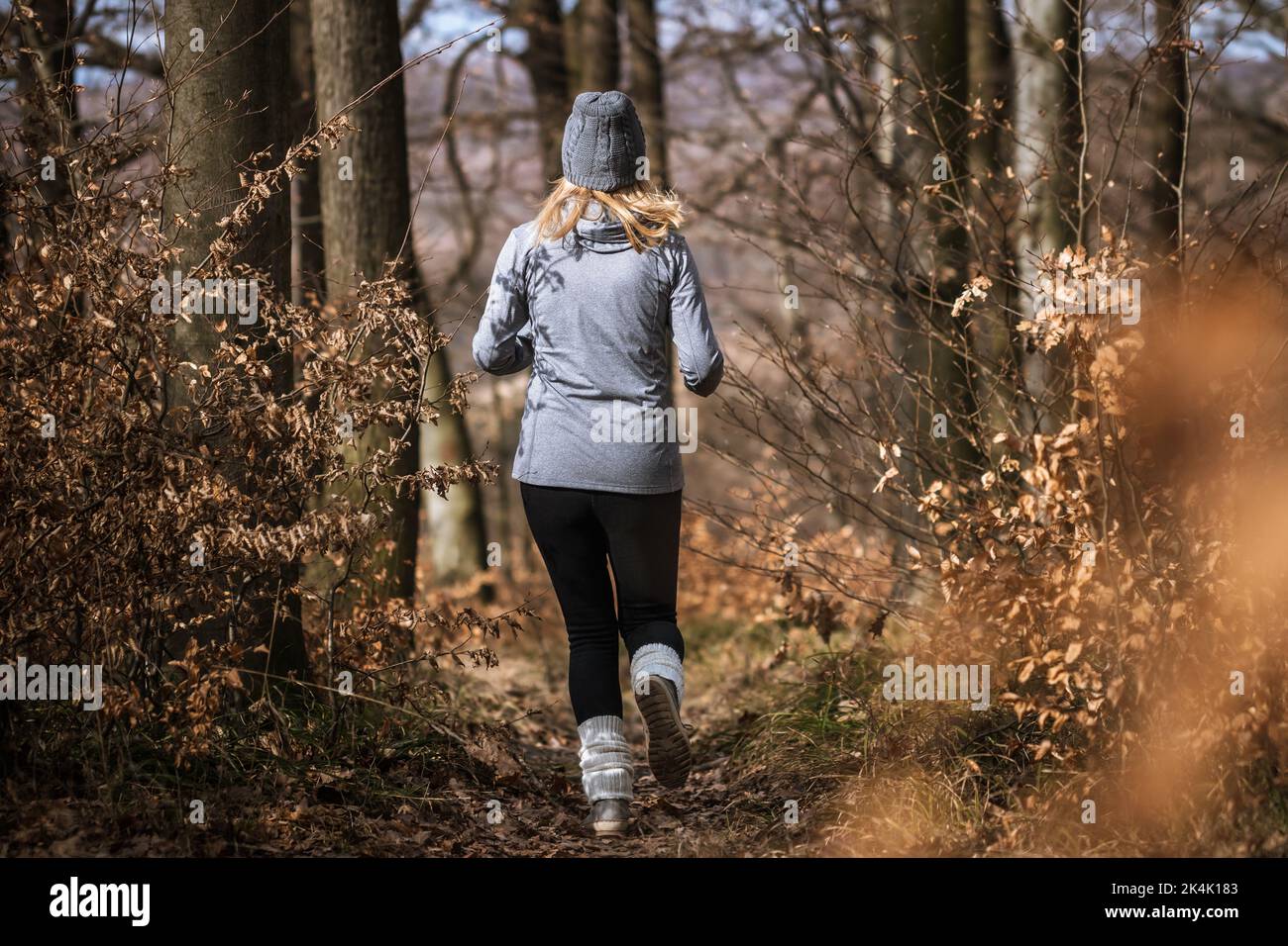 Entrenamiento de fitness y jogging en el bosque de otoño. Mujer corriendo al aire libre. Actividad deportiva en la naturaleza Foto de stock
