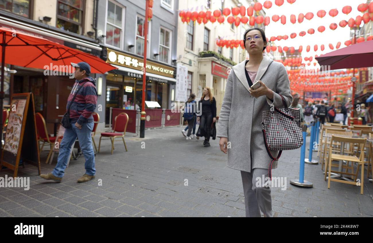 Londres, Inglaterra, Reino Unido. Joven china caminando por Chinatown Foto de stock