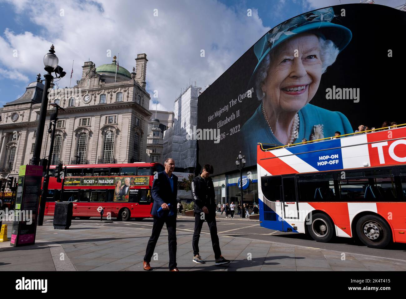 Con la publicidad suspendida, los visitantes y turistas en Piccadilly Circus interactúan debajo de una imagen a color de la Reina Isabel II que está en exhibición en las pantallas publicitarias a gran escala el día siguiente a su muerte el 9th de septiembre de 2022 en Londres, Reino Unido. La Reina, que tenía 96 años, reinó como monarca del Reino Unido y de la Commonwealth durante 70 años. Foto de stock
