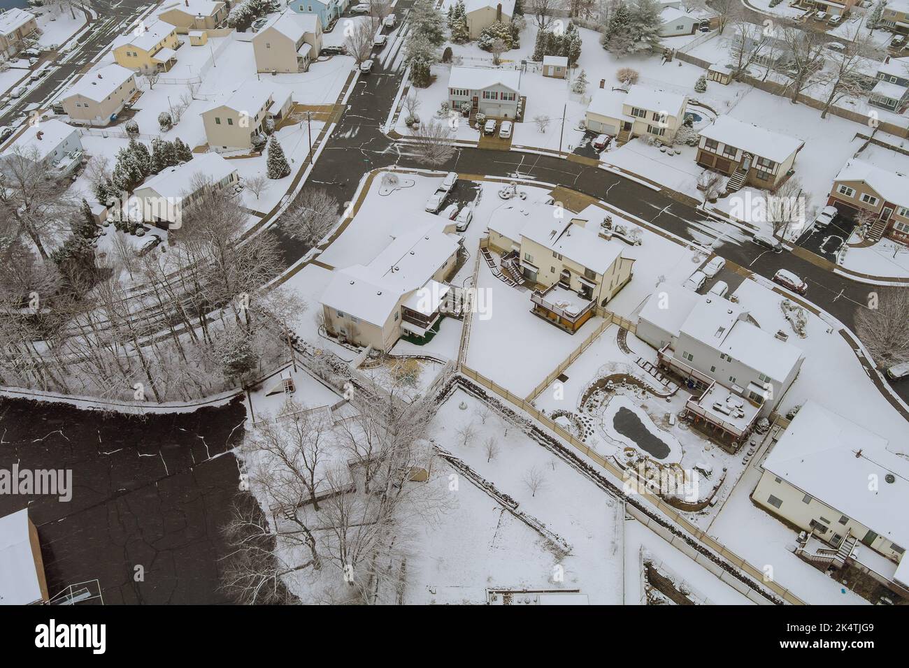 Un pequeño pueblo estadounidense en Nueva Jersey tiene un complejo de casas con techos cubiertos de nieve durante la nevada de invierno durante una tormenta de nieve Foto de stock