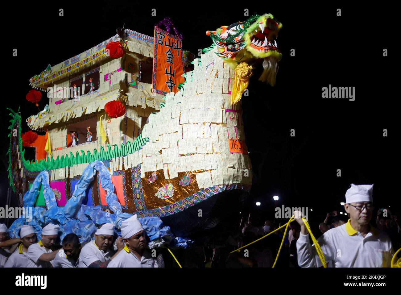 Los devotos llevan un barco de dragón de papel mientras participan en un ritual para enviar a los dioses al mar durante el último día del festival Taoísta de los Nueve Dioses Emperadores en Singapur, el 4 de octubre de 2022. REUTERS/Edgar Su Foto de stock