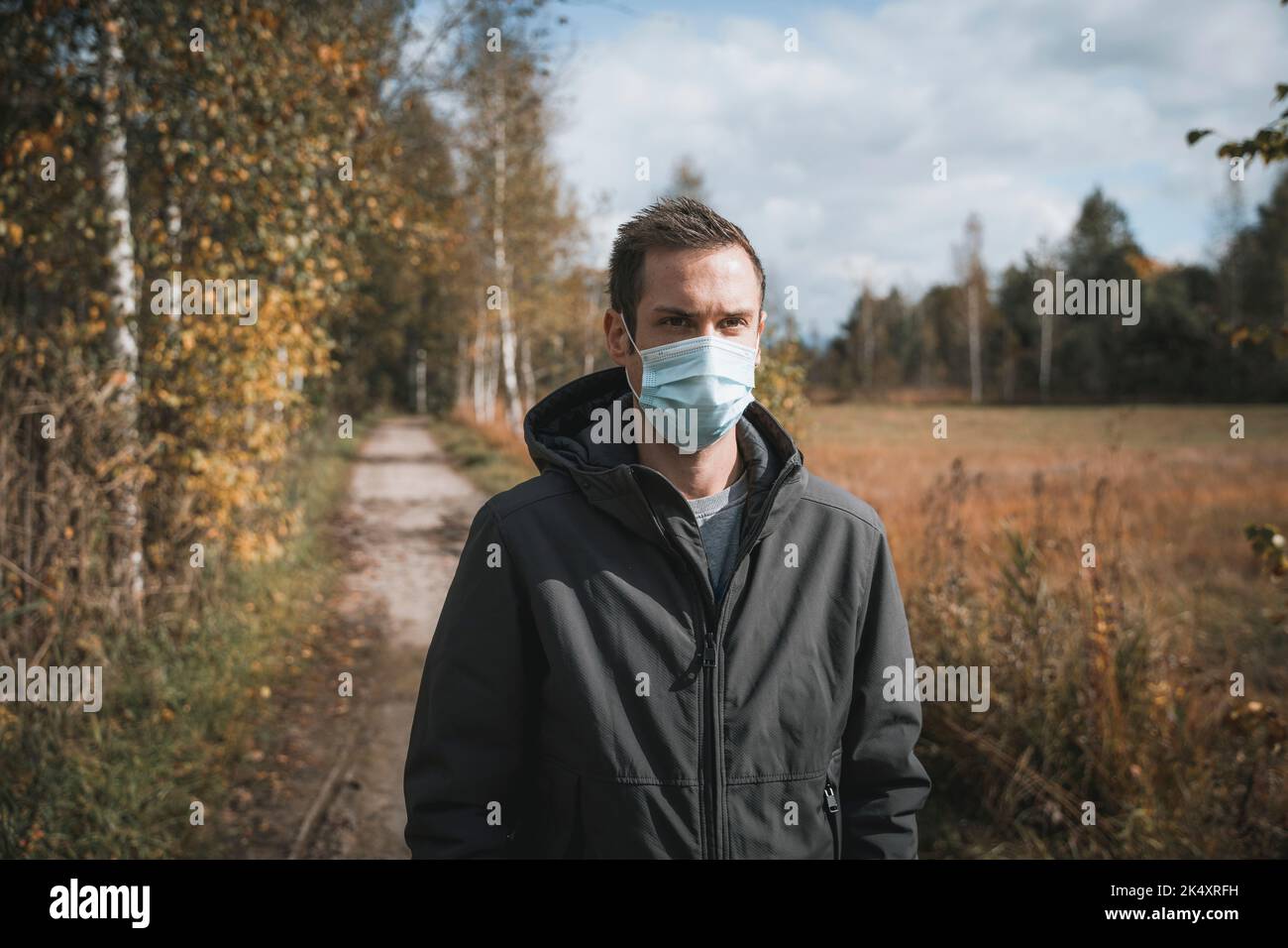 03 de octubre de 2022: Joven con máscara protectora durante la caminata otoñal al aire libre, máscara para protegerse del virus Corona, Covid 19. Símbolo ima Foto de stock