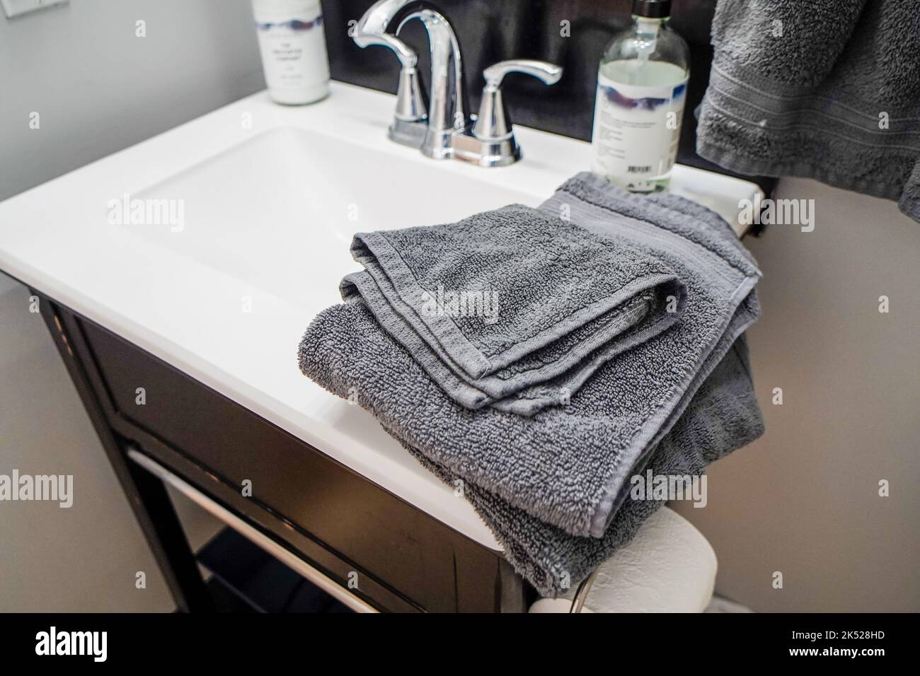toallas grises en el lavabo del baño moderno Foto de stock