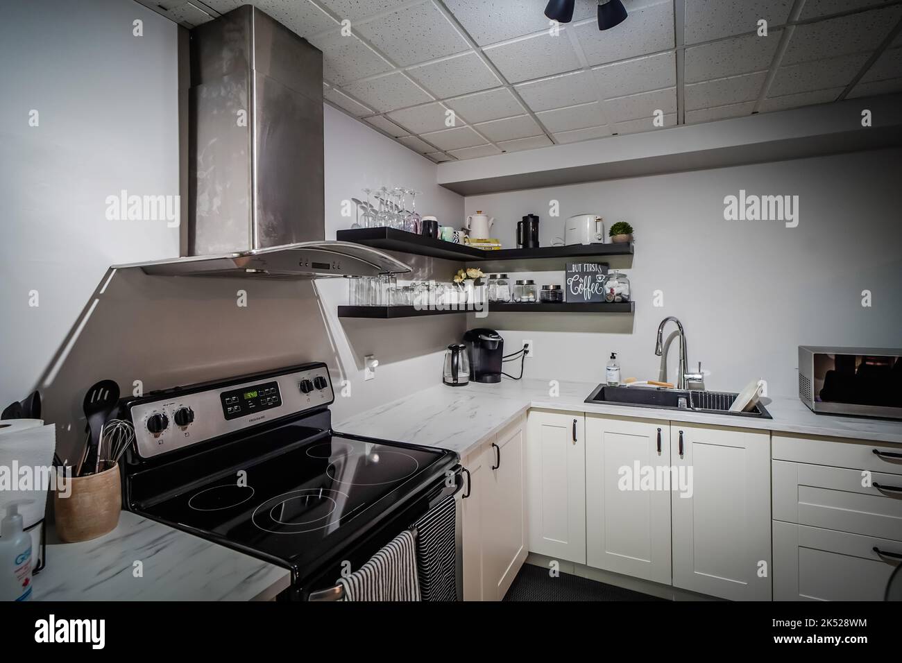 pequeña cocina con cocina, encimera, microondas, diseño moderno Foto de stock