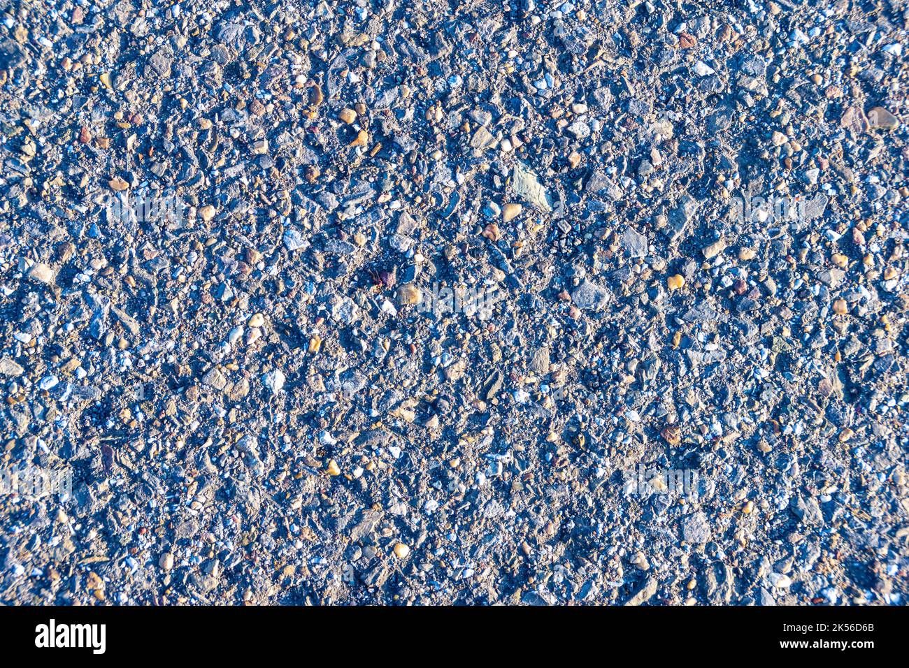 textura de pavimento de asfalto viejo iluminado por el sol de la noche baja, enfoque selectivo Foto de stock