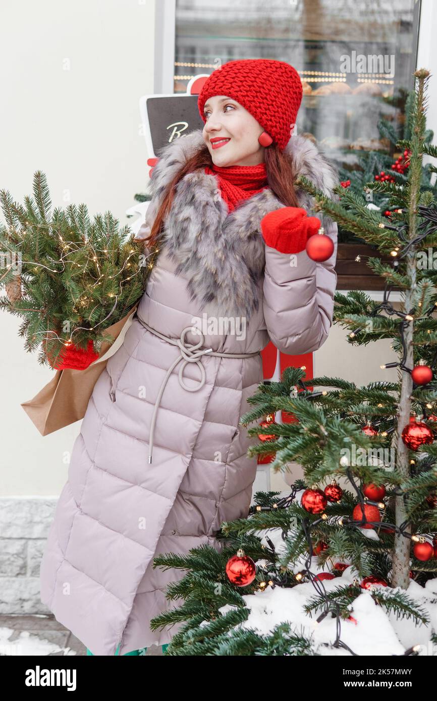 Una mujer brillante con ropa de invierno camina por la ciudad decorada para  la Navidad. Estilo de vida en la temporada de invierno Fotografía de stock  - Alamy