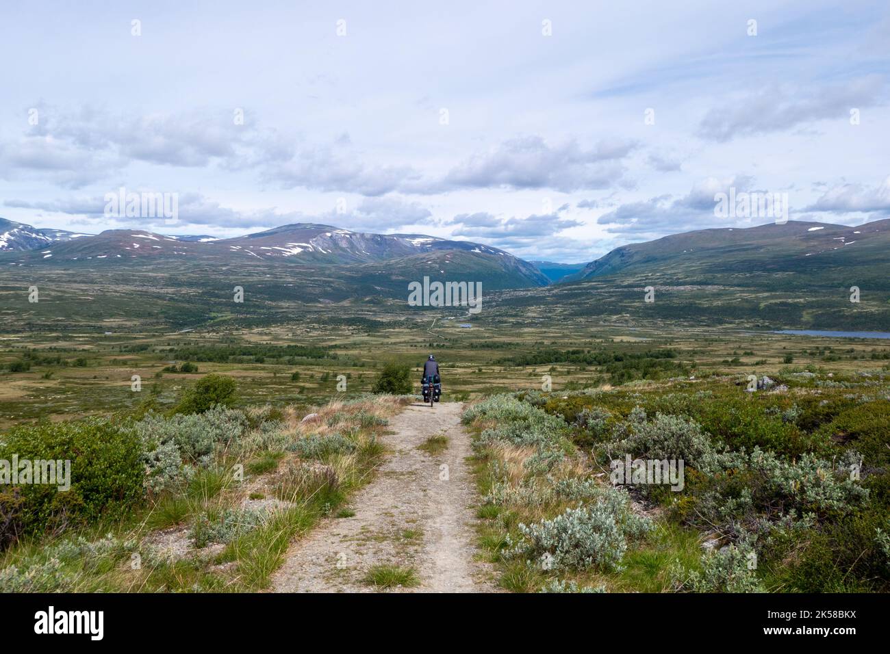 Ciclista en el camino de tierra en el hermoso Parque Nacional Rondane, Noruega Foto de stock