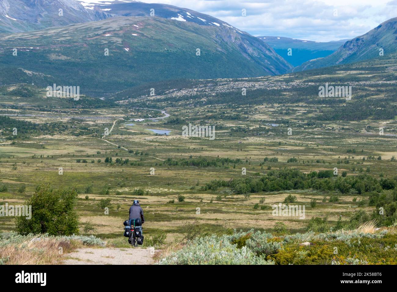 Ciclista en el camino de tierra en el hermoso Parque Nacional Rondane, Noruega Foto de stock