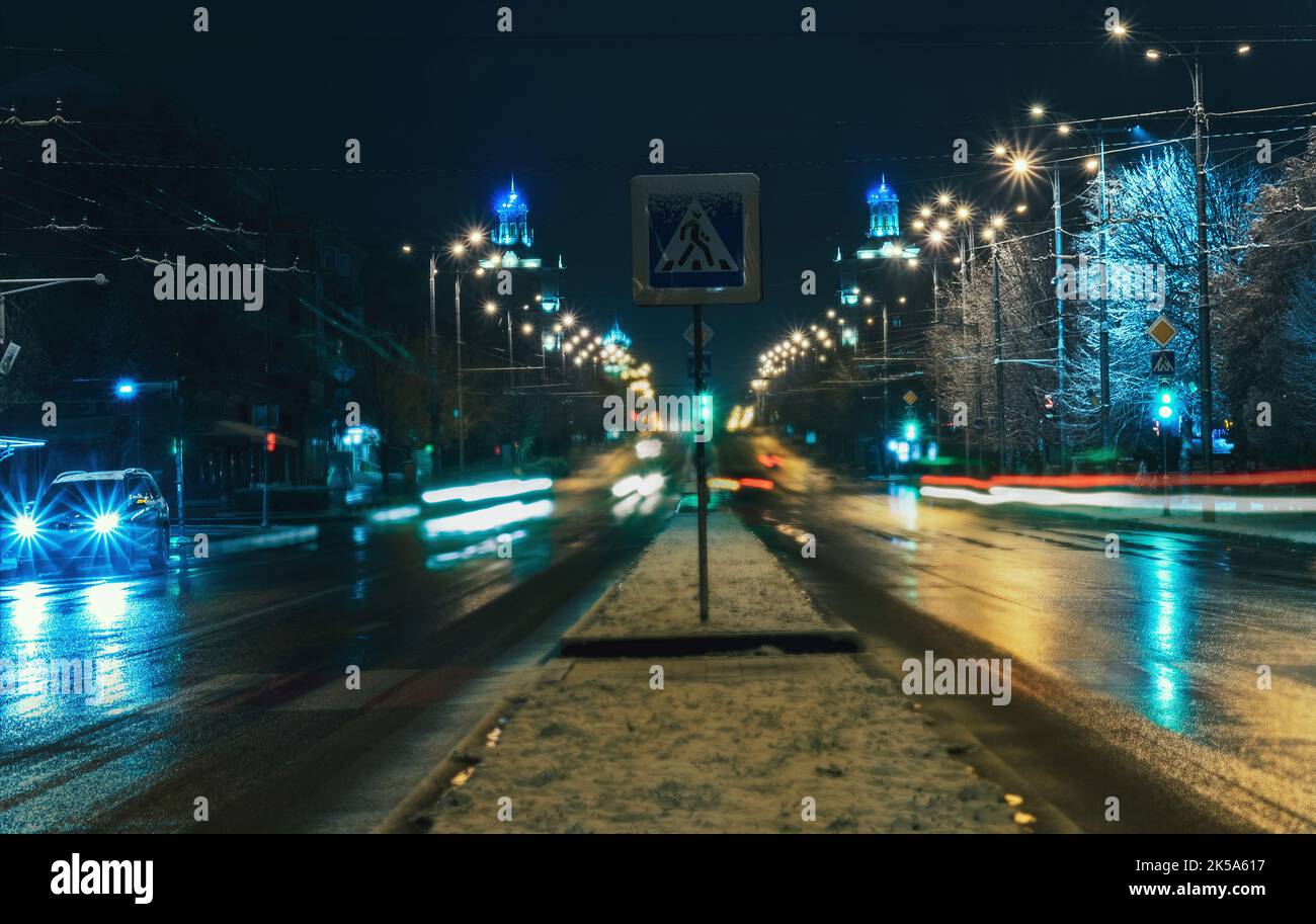 Tráfico nocturno en la ciudad. Carretera nocturna en la ciudad de las luces de tráfico de coches con signo de cruce Foto de stock