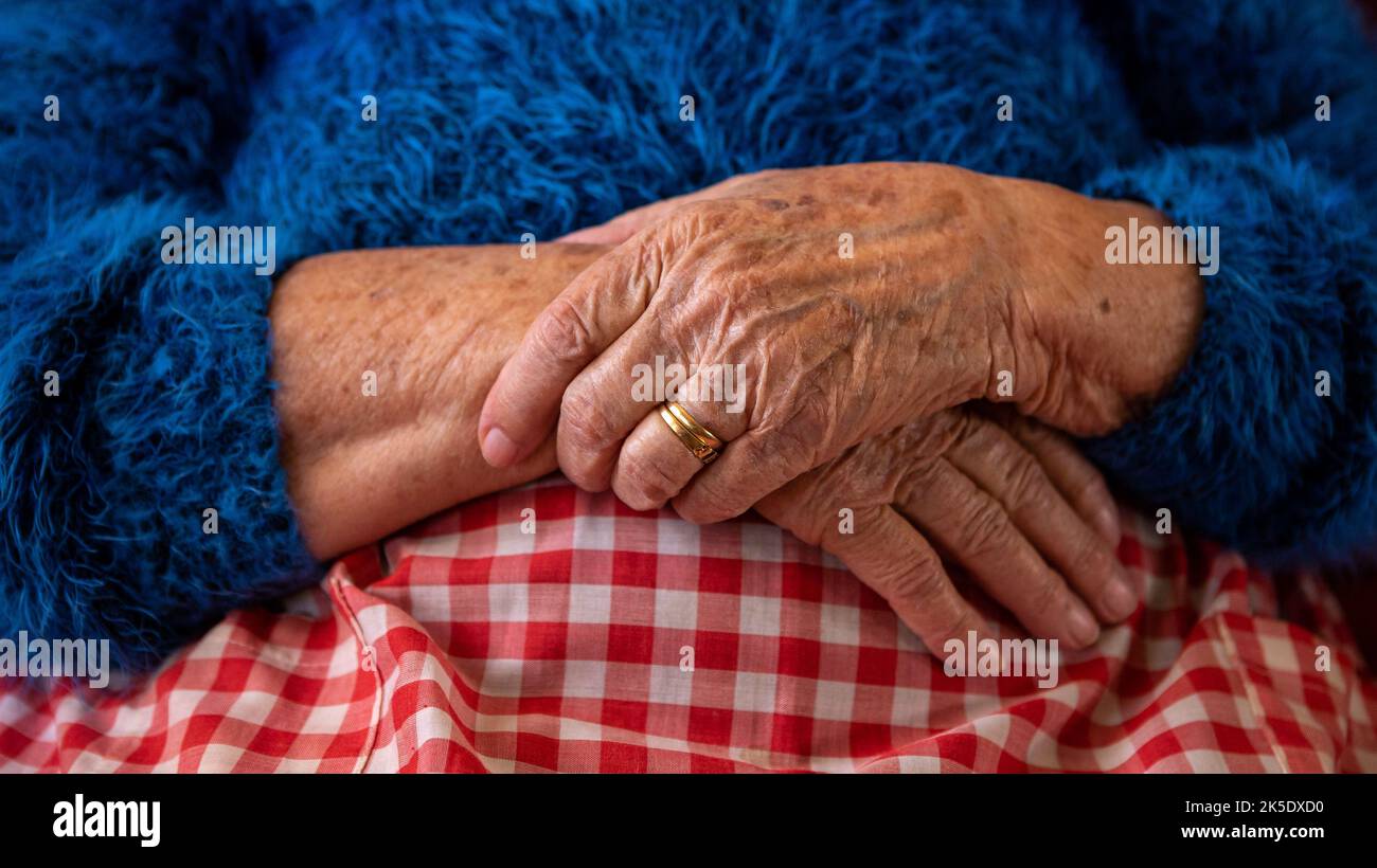 De cerca las manos de una anciana viuda. Caucásica 90s abuela sentada en casa. Las manos arrugadas de la abuela Foto de stock