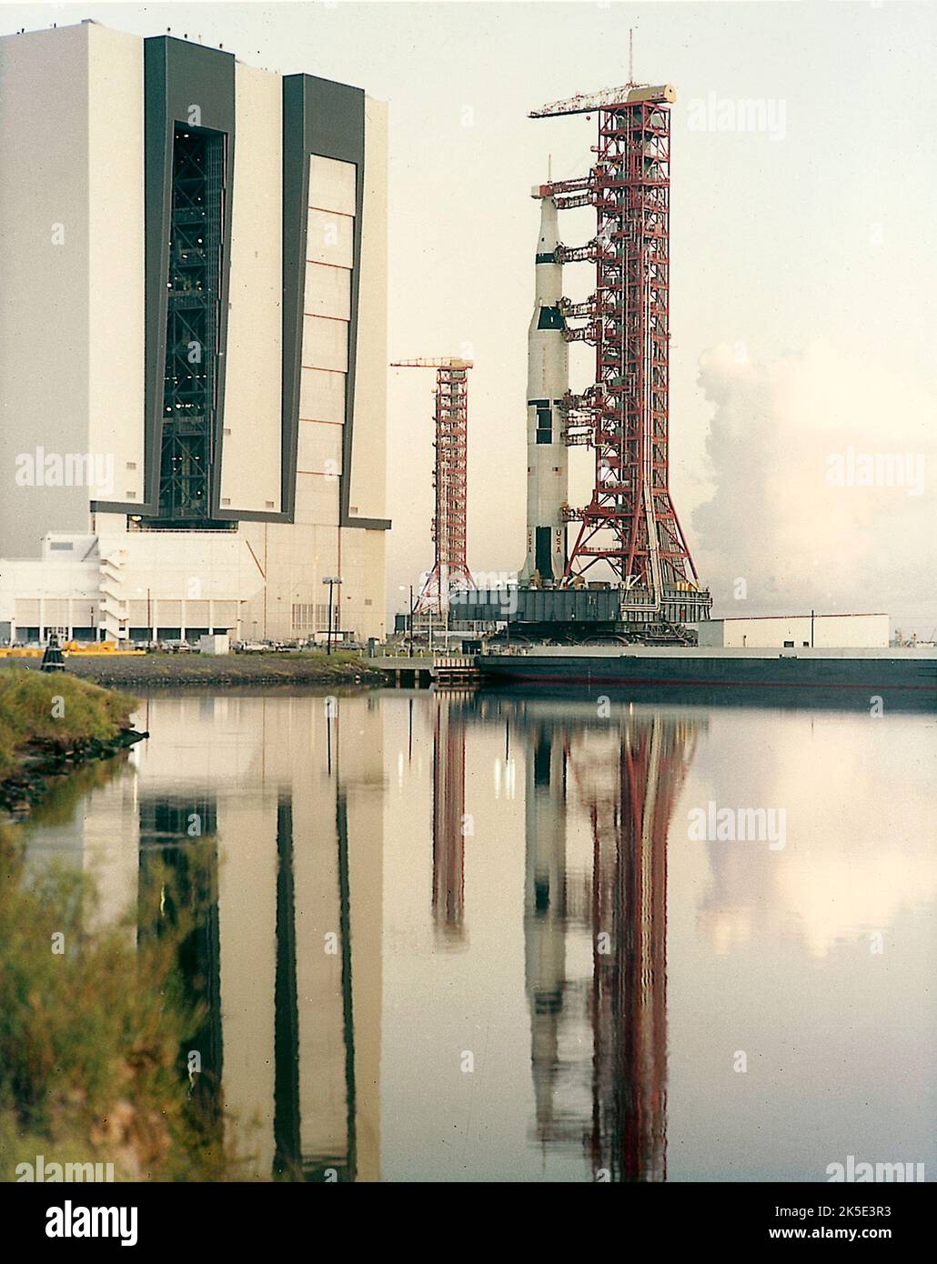 En agosto de 1967, el vehículo Saturn V (SA-501), salió a la plataforma de lanzamiento en preparación para su primer lanzamiento. El cohete de 363 pies de altura salió del edificio de la Asamblea de Vehículos y se dirigió a la plataforma de lanzamiento en el Centro Espacial Kennedy, Florida. La misión Apollo 4 fue un vuelo de prueba sin tripulación diseñado para obtener información de vuelo sobre la integridad estructural y la compatibilidad de vehículos de lanzamiento y naves espaciales, cargas de vuelo, separación de etapas y funcionamiento de subsistemas, y para evaluar el escudo térmico del módulo de comando Apollo. El lanzamiento tuvo lugar el 9 de noviembre de 1967. Imagen optimizada de la NASA: Crédito: NASA Foto de stock