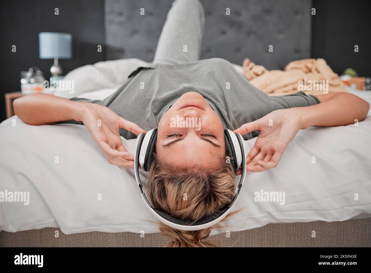 Dormir música, cama y mujer escuchando audio podcast con auriculares en el  dormitorio de su casa. Chica durmiente streaming de sonido de radio calma  para la paz Fotografía de stock - Alamy