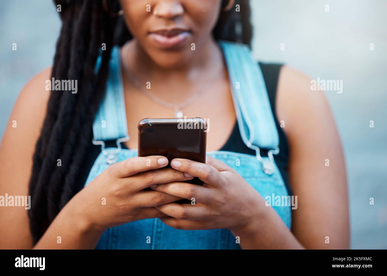 Mujer negra manos con teléfono inteligente para los medios sociales, información de contacto en el sitio web o la lectura en línea blog boletín de noticias en el estilo de vida urbano de la juventud. Adolescente Foto de stock