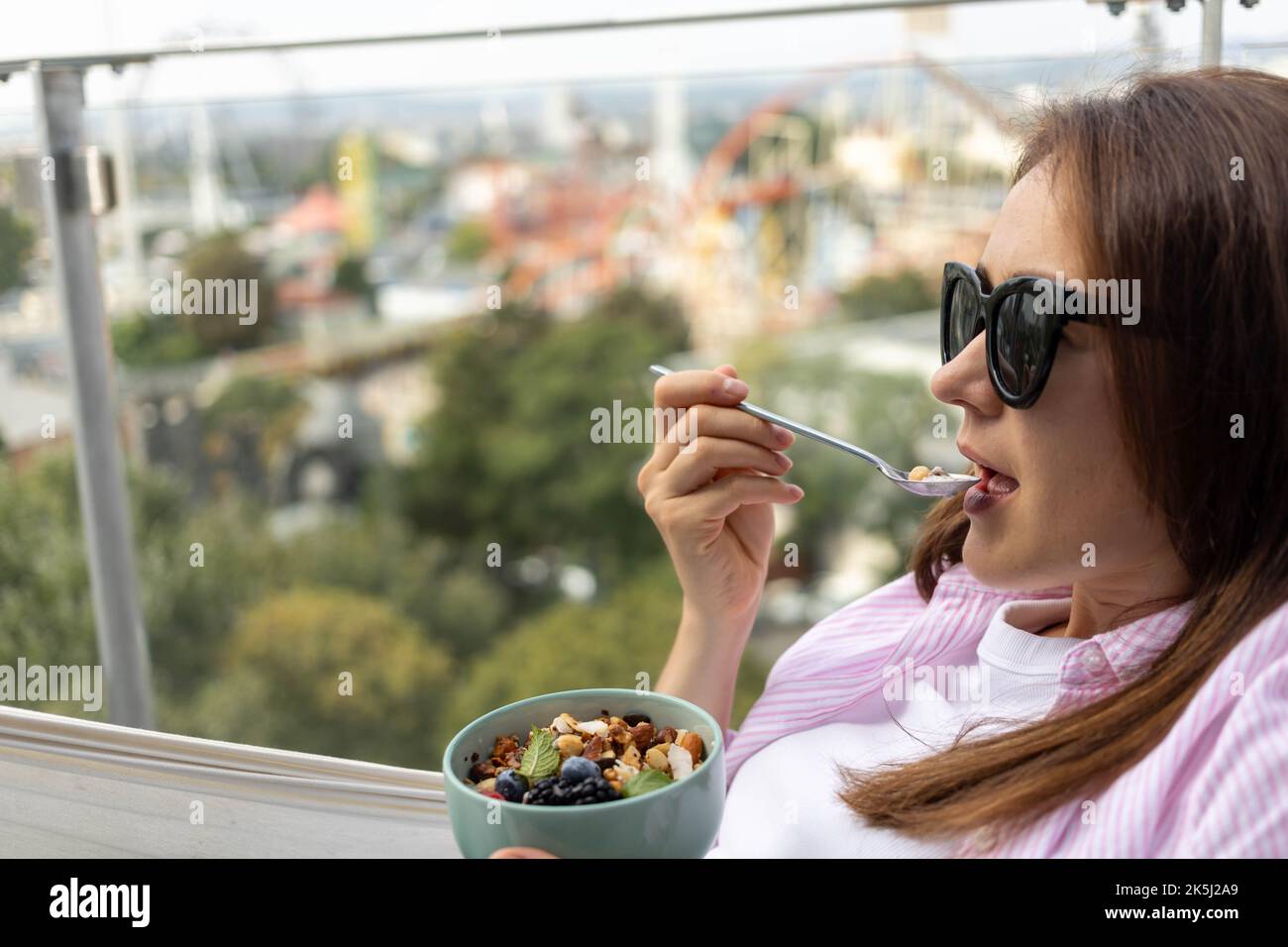 mujer joven comiendo chía pudding con frutos secos y bayas Foto de stock